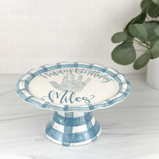 Gingham blue cake-stand decorated with a child's handprint 
