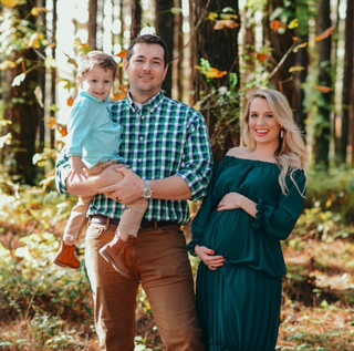 Pregnant mom with husband and son in a forest.