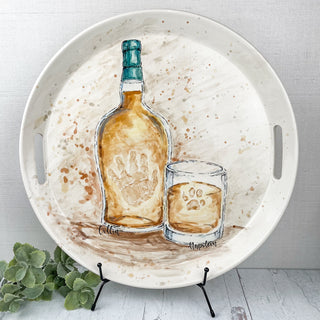 Large circular platter decorated with Bourbon themed artwork made with a paw print and a child's handprint. 