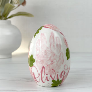 Pink floral easter egg made with a child's handprint.