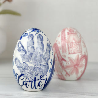 Blue and pink easter eggs with a child's handprint.