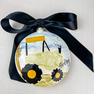 Round ornament decorated with a green tractor made from a child's footprint