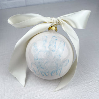 Round ornament decorated with a child's handprint