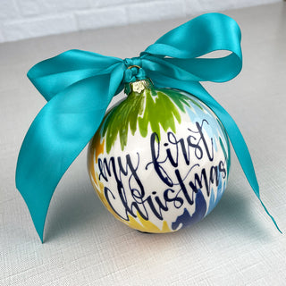 Round ornament decorated with colorful line art and "My First Christmas" 