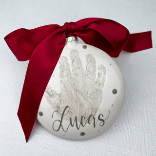 White circular ornament decorated a child's handprint. 