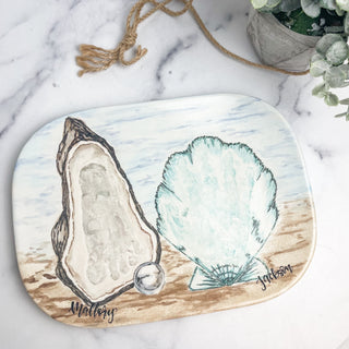 Beach themed platter with an oyster made from a child's footprint as well as a clam made from a child's handprint.