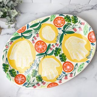 Large platter decorated with citrus fruits made with four handprints.