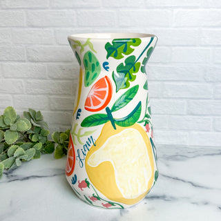 Large vase decorated with citrus fruits made with a child's handprint.