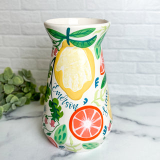 Large vase decorated with citrus fruits made with a child's handprint.